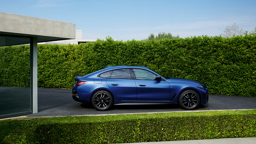 Изглед отзад BMW i4 M50 G26 2021 в движение по междуградски път BMW i4 M50 G26 2021 BMW Individual Frozen Portimao Blue metallic изглед отзад в движение по междуградски път
