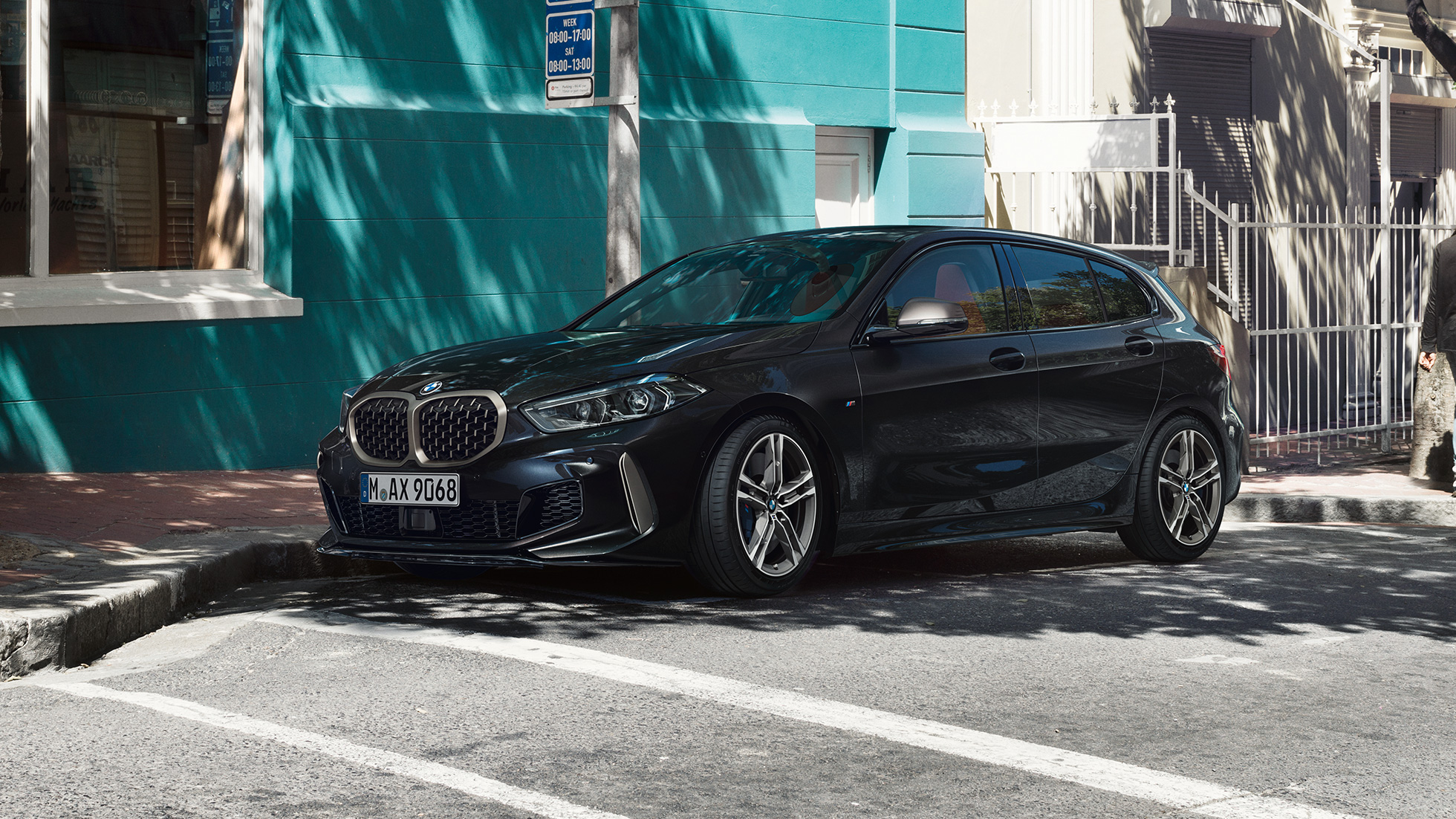 BMW M135i xDrive, три четвърти изглед отстрани BMW M135i xDrive в Black Sapphire metallic, три четвърти изглед отстрани, паркирано.