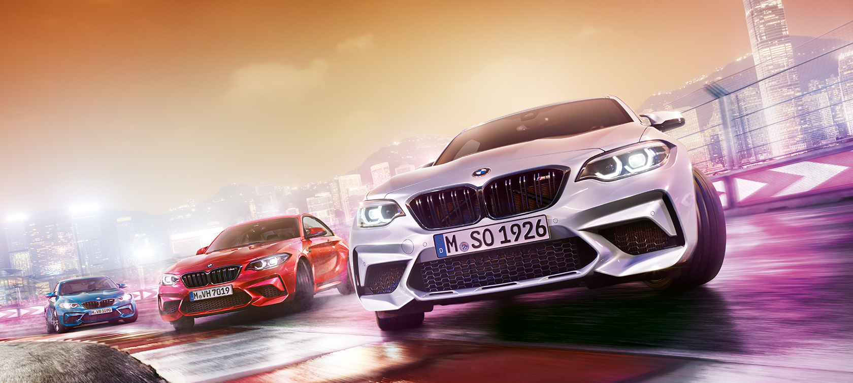 BMW M2 Competition в действие 3 модела BMW M2 Compeititon дрифтират на състезателна писта около града.