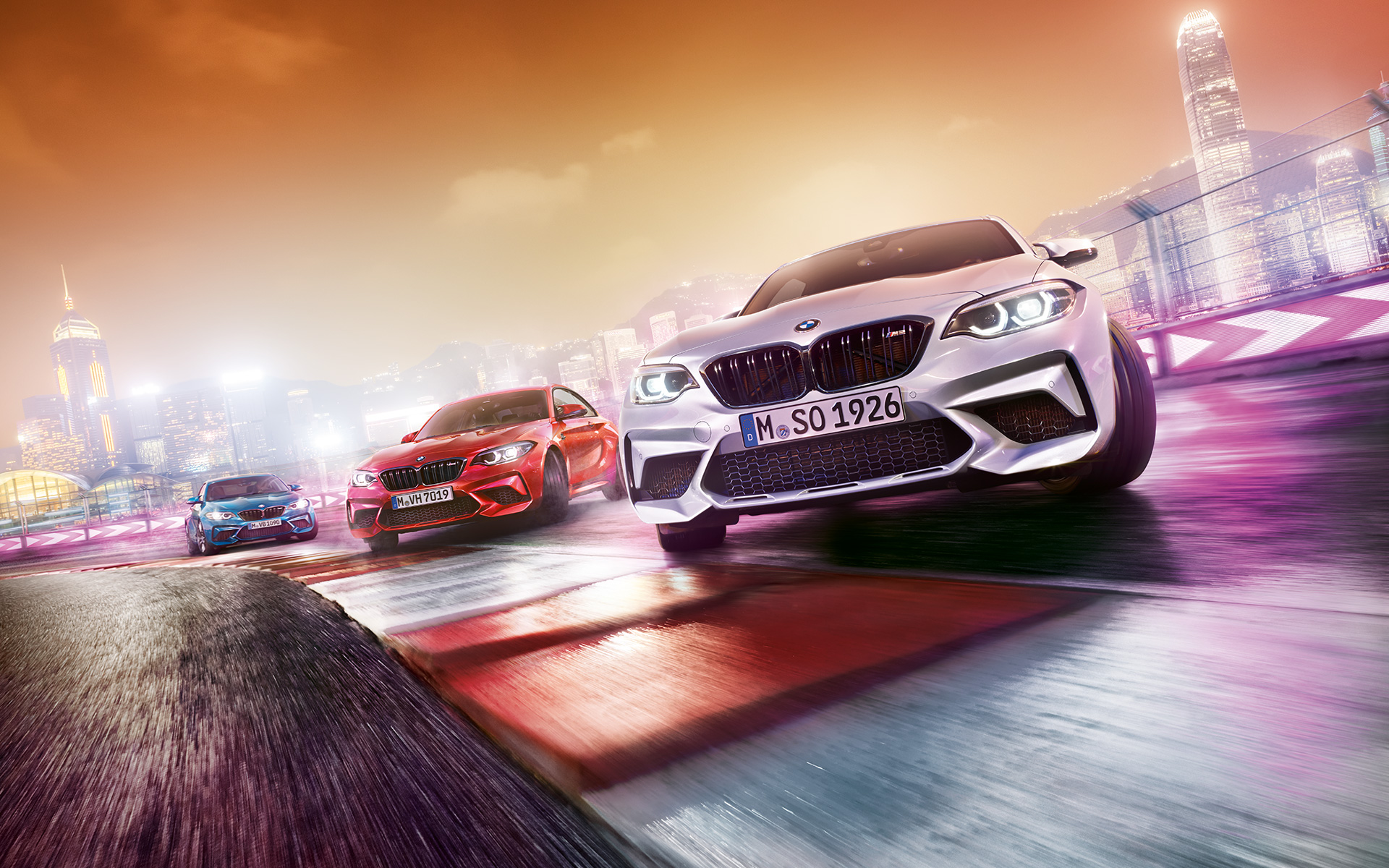 BMW M2 Competition в действие Три модела BMW M2 Compeititon на състезателна писта около града.