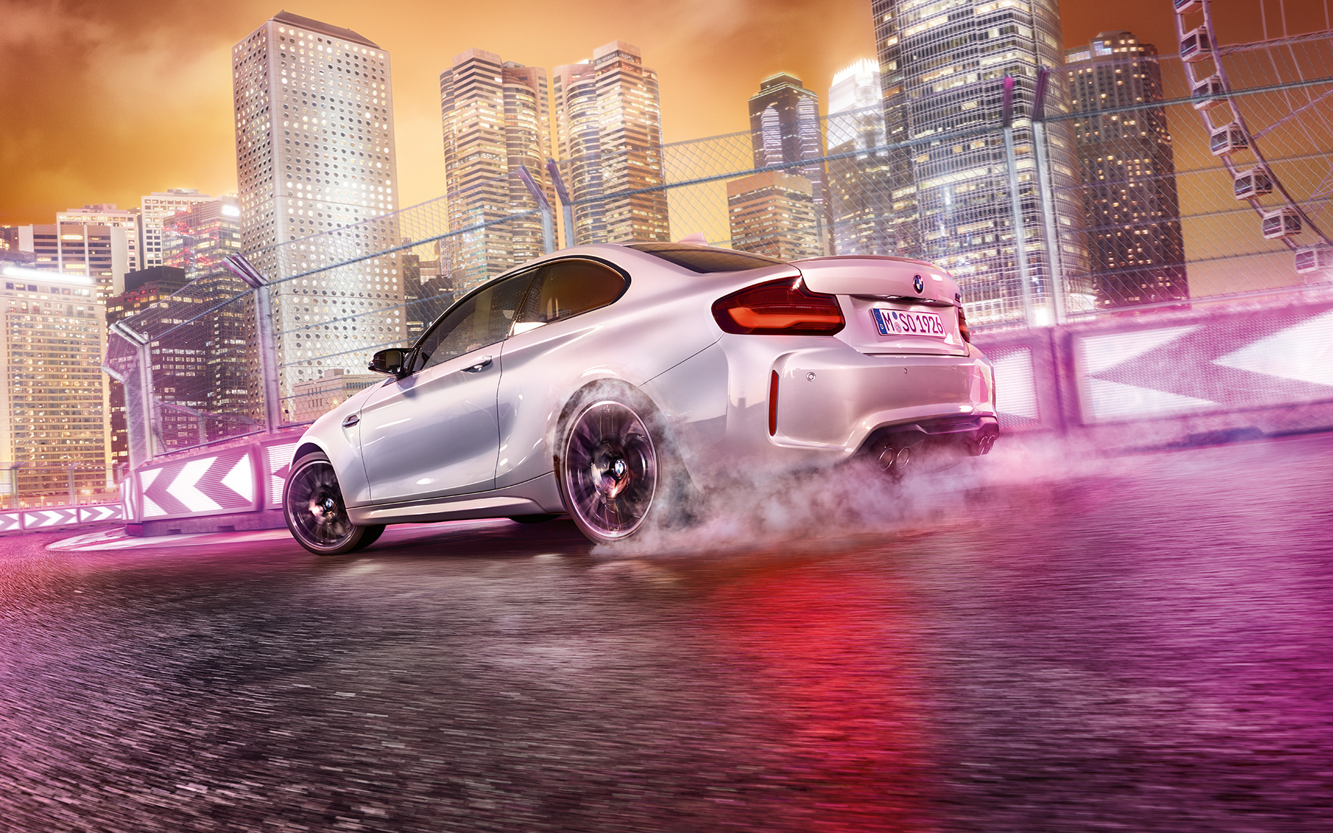 BMW M2 Competition ускорява. Бяло BMW M2 Compeititon дрифтира на състезателна писта.