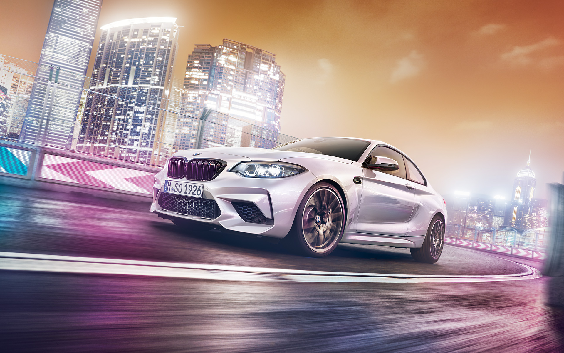 Бяло BMW M2 Competition Бяло BMW M2 Compeititon се движи по състезателна писта.