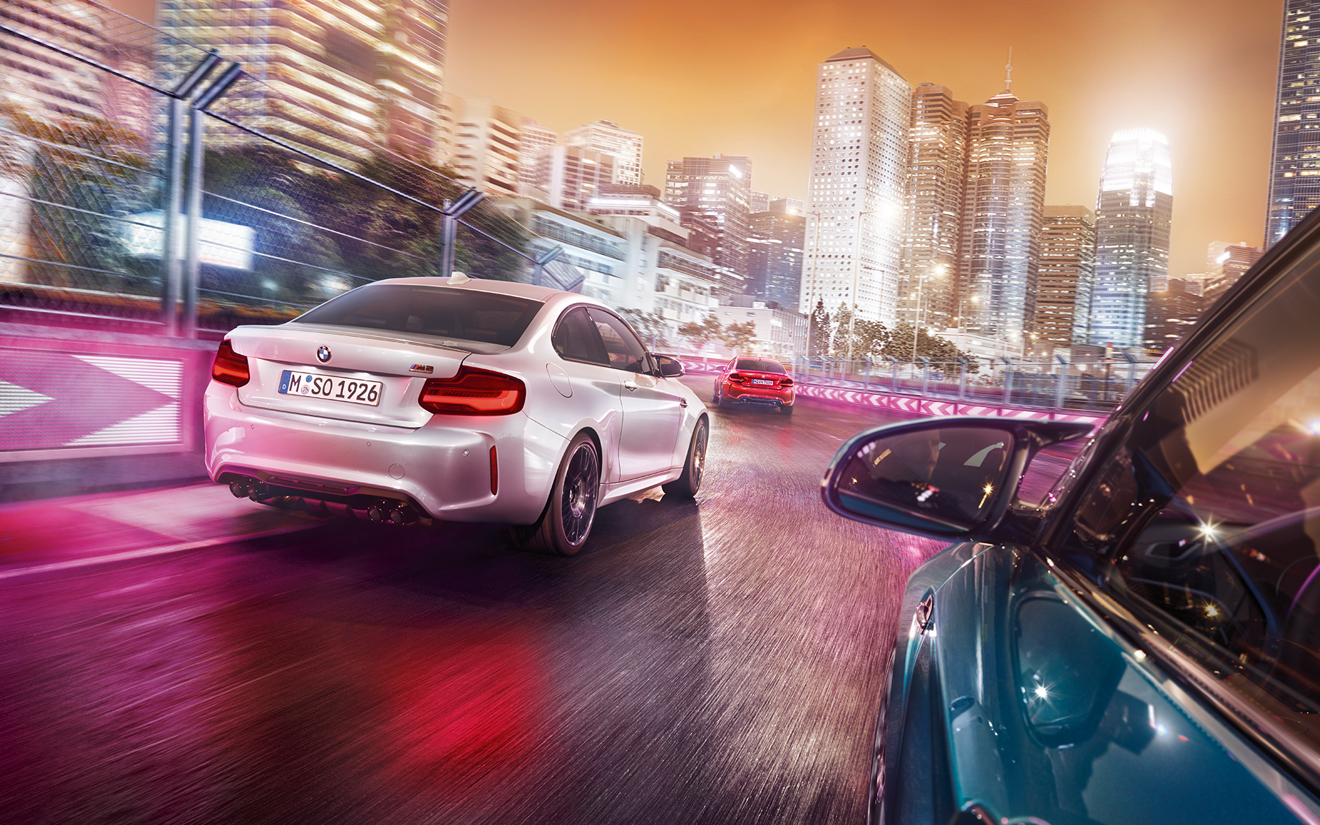 BMW M2 Competition отзад Три модела BMW M2 Compeititon с изглед отзад се движат по състезателна писта.