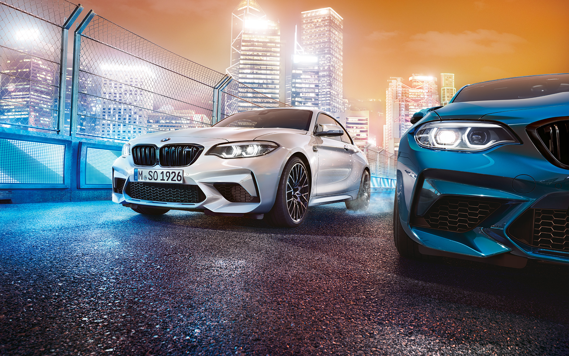 BMW M2 Competition отзад Три модела BMW M2 Compeititon с изглед отзад се движат по състезателна писта.
