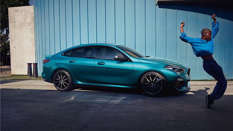 BMW M235i xDrive Гран Купе F44 изглед отстрани с жена на преден план BMW M235i xDrive Гран Купе F44 Snapper Rocks Blue metallic изглед отстрани с жена на преден план