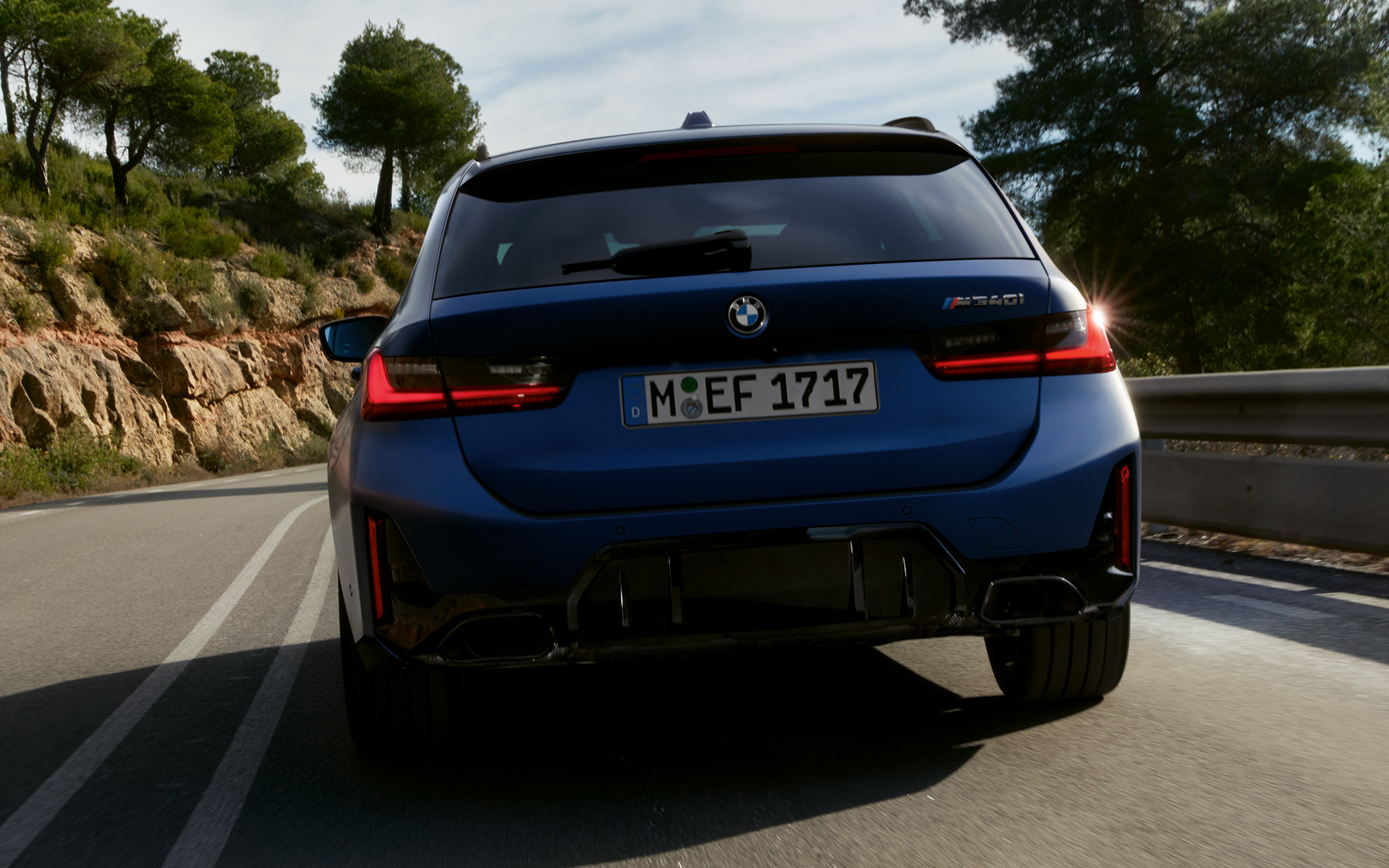 BMW M340i xDrive Туринг G21 Tanzanite Blue изглед отзад в движение по пътя