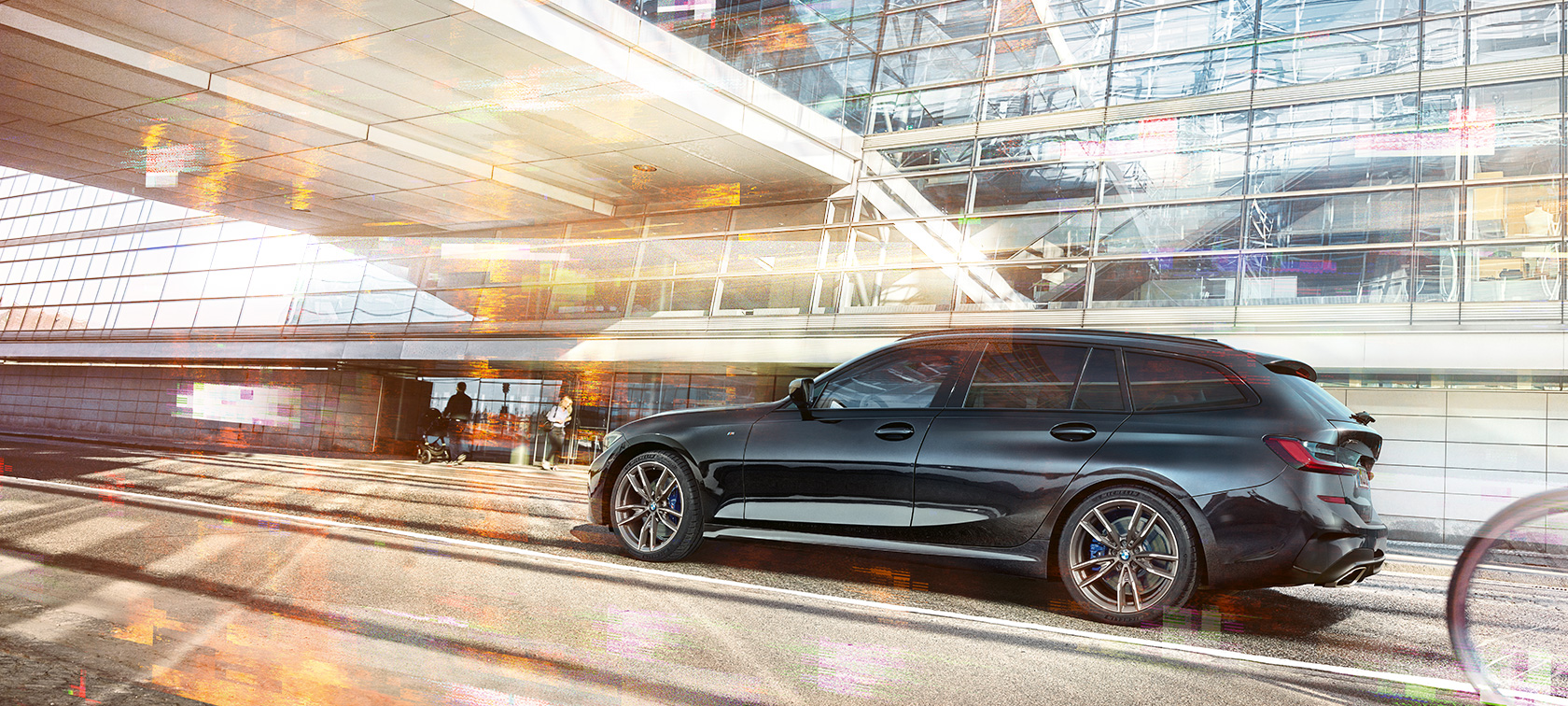 BMW M340i xDrive Туринг, странична снимка в движение BMW M340i xDrive Туринг, странична снимка в движение на фона на стъклена сграда