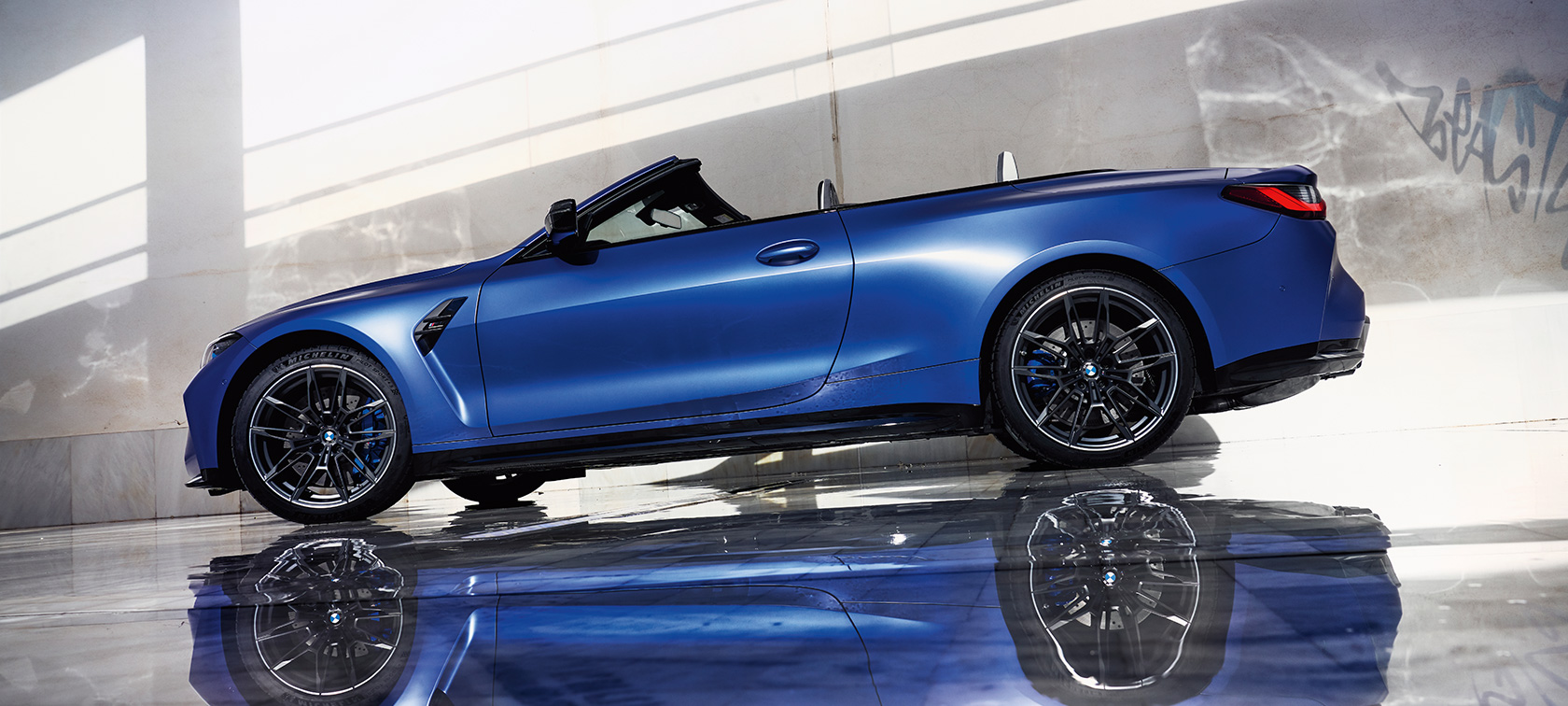 BMW M4 Competition Кабриолет с М xDrive G83 2021 три четвърти изглед отпред в движение BMW M4 Competition Кабриолет с М xDrive G83 2021 BMW Individual Frozen Portimao Blue metallic три четвърти изглед отпред в движение
