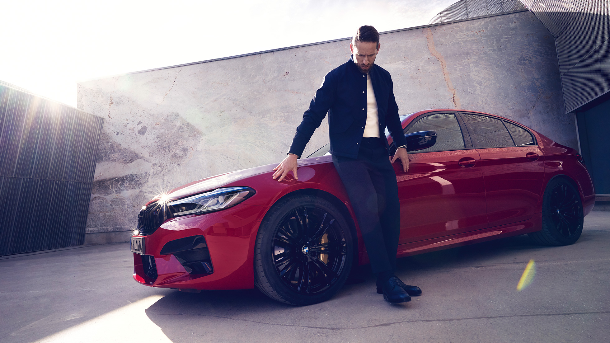 BMW M5 Competition F90 LCI Facelift 2020 изглед отстрани с мъж BMW M5 Competition F90 LCI Facelift 2020 BMW Individual Imola Red изглед отстрани с мъж