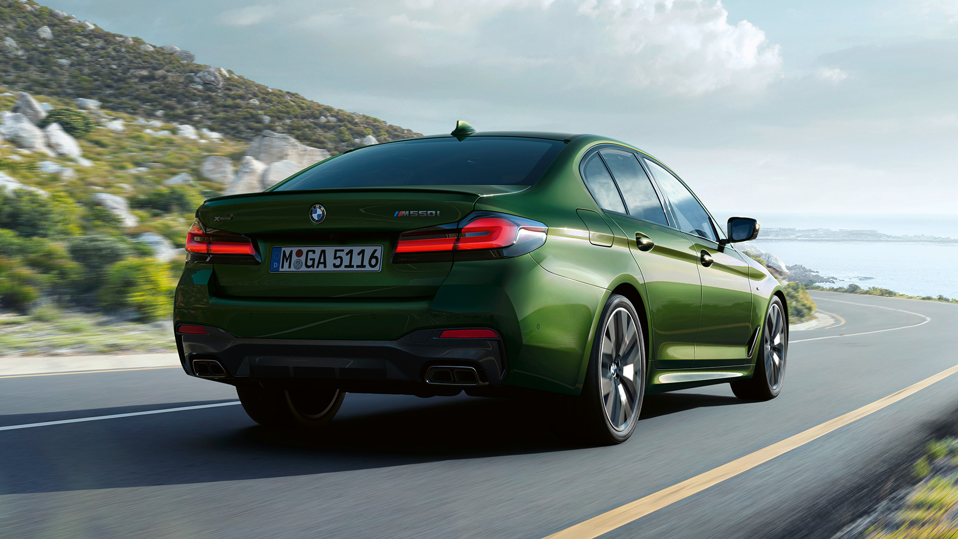 BMW M550i xDrive Седан G30 LCI Facelift 2020 изглед отзад BMW M550i xDrive Седан G30 LCI Facelift 2020 BMW Individual Verde Ermes metallic изглед отстрани в движение по междуградски път