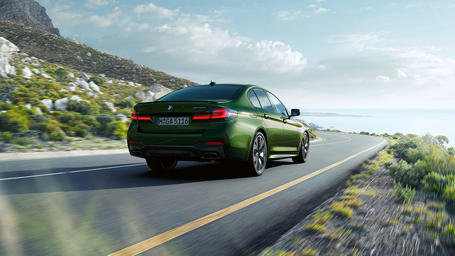 BMW M550i xDrive Седан G30 LCI Facelift 2020 BMW Individual Verde Ermes metallic три четвърти изглед отзад в движение