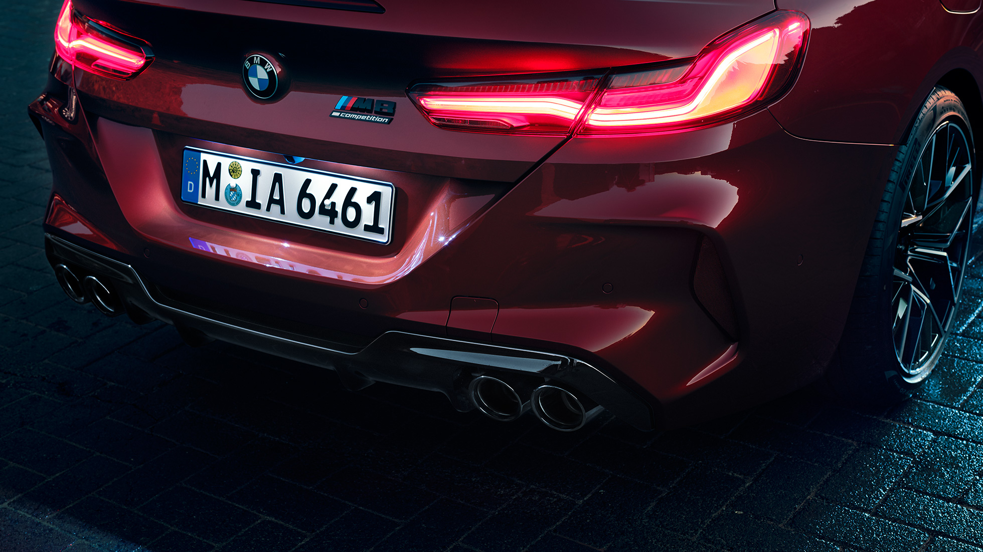BMW M8 Competition Кабриолет, снимка отблизо на задната част. BMW M8 Competition Кабриолет в цвят Motegi Red metallic, снимка отблизо на задната част с LED задни светлини и емблема M8 Competiton.