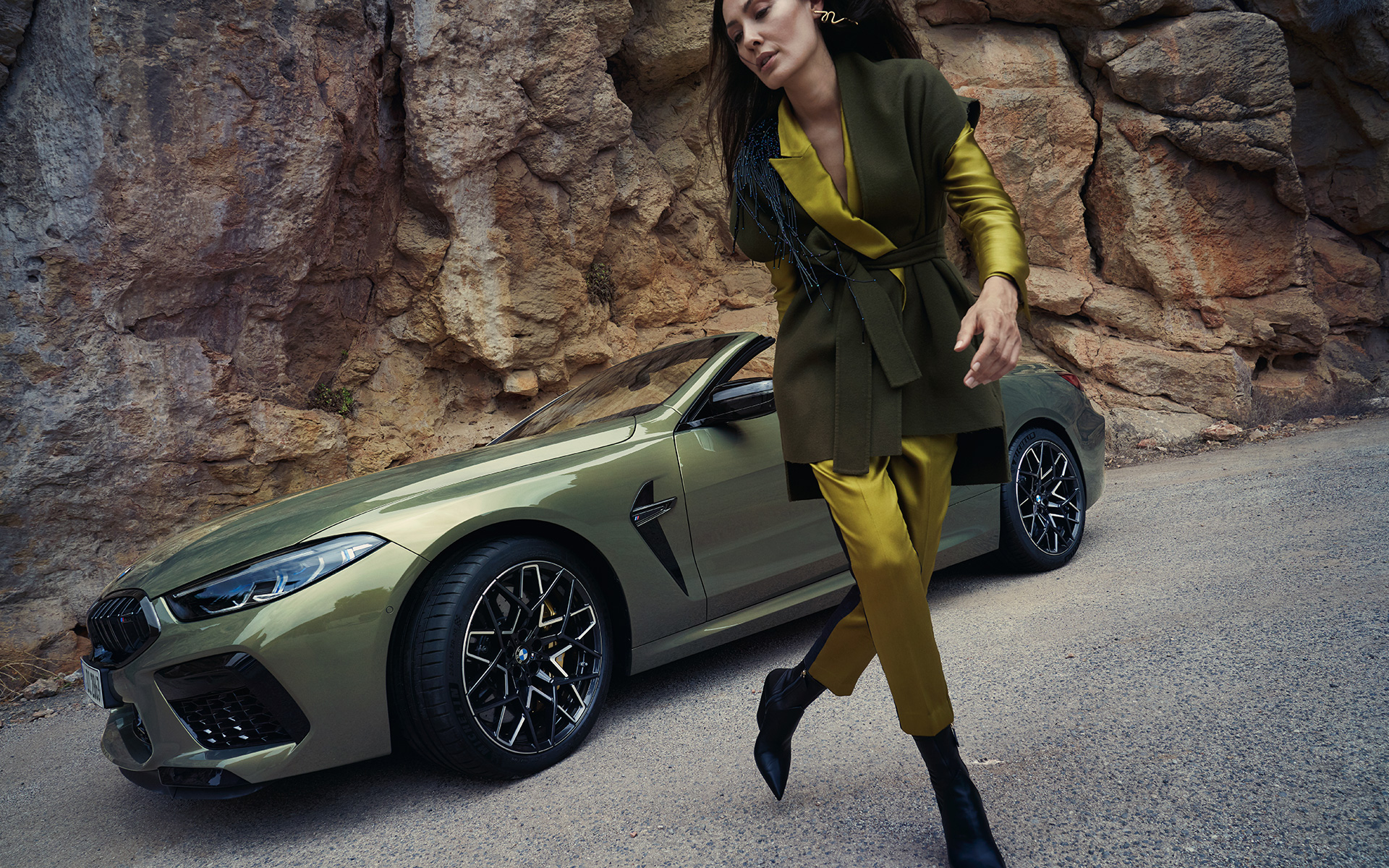 BMW M8 Competition Кабриолет F91 LCI фейслифт 2022 три-четвърти изглед отпред в покой на каменист терен с модел BMW M8 Competition Кабриолет F91 LCI фейслифт 2022 BMW Individual Brass metallic три-четвърти изглед отпред в покой на каменист терен с модел