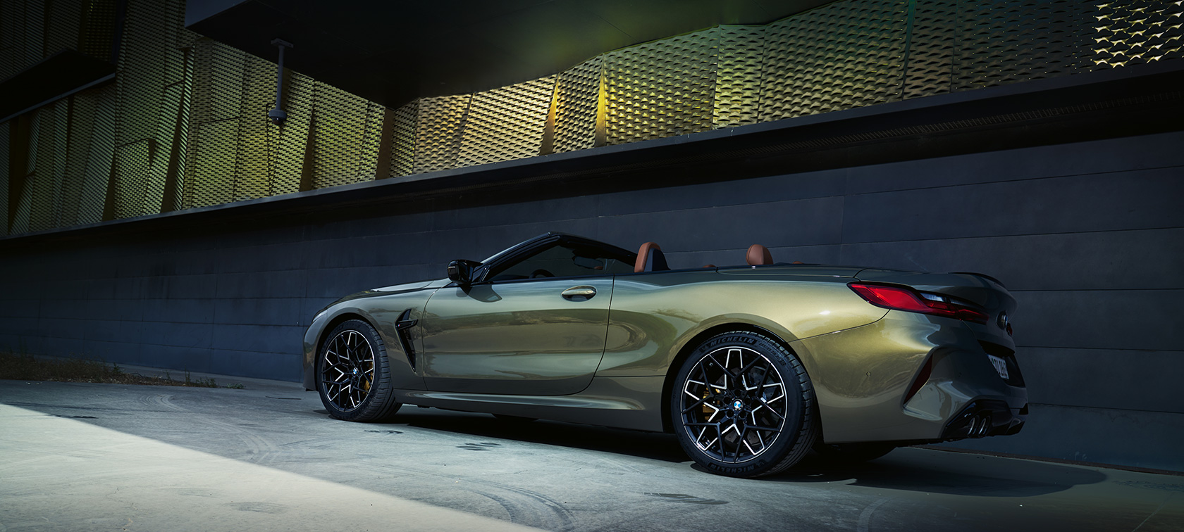 BMW M8 Competition Кабриолет F91 LCI фейслифт 2022 BMW Individual Brass metallic три четвърти изглед отстрани в покой пред стена