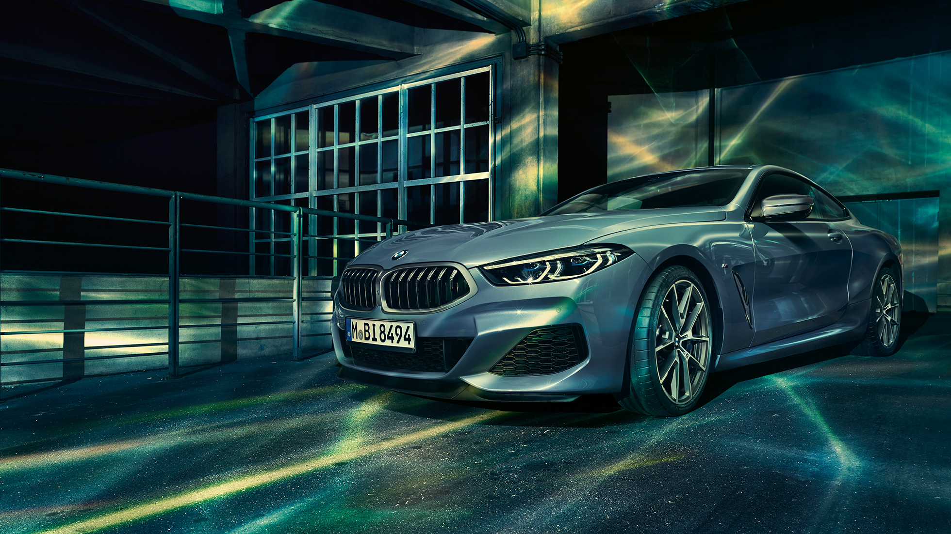 BMW M850i xDrive Купе, три четвърти изглед отпред. BMW M850i xDrive Купе в Barcelona Blue metallic, три четвърти изглед отпред в покой пред сграда.