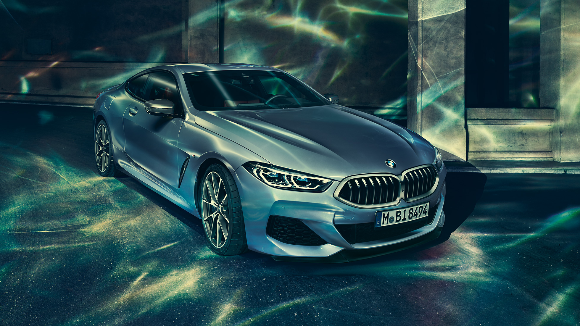 BMW M850i xDrive Купе, три четвърти изглед отпред отляво. BMW M850i xDrive Купе в Barcelona Blue metallic, три четвърти изглед отпред отляво, в покой пред сграда