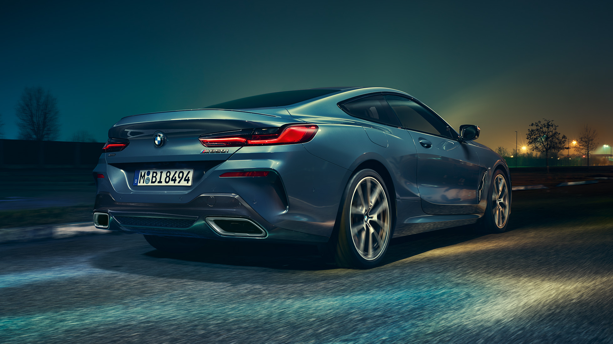 BMW M850i xDrive Купе, изглед отзад. BMW M850i xDrive Купе в Barcelona Blue metallic, изглед отзад, в движение през нощта.