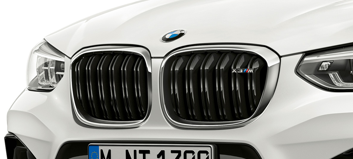BMW X3 M, М бъбрековидна радиаторна решетка. BMW X3 M в цвят Alpine White, екстериор, предна част, М бъбрековидна радиаторна решетка с хромирани акценти и означение на модела.