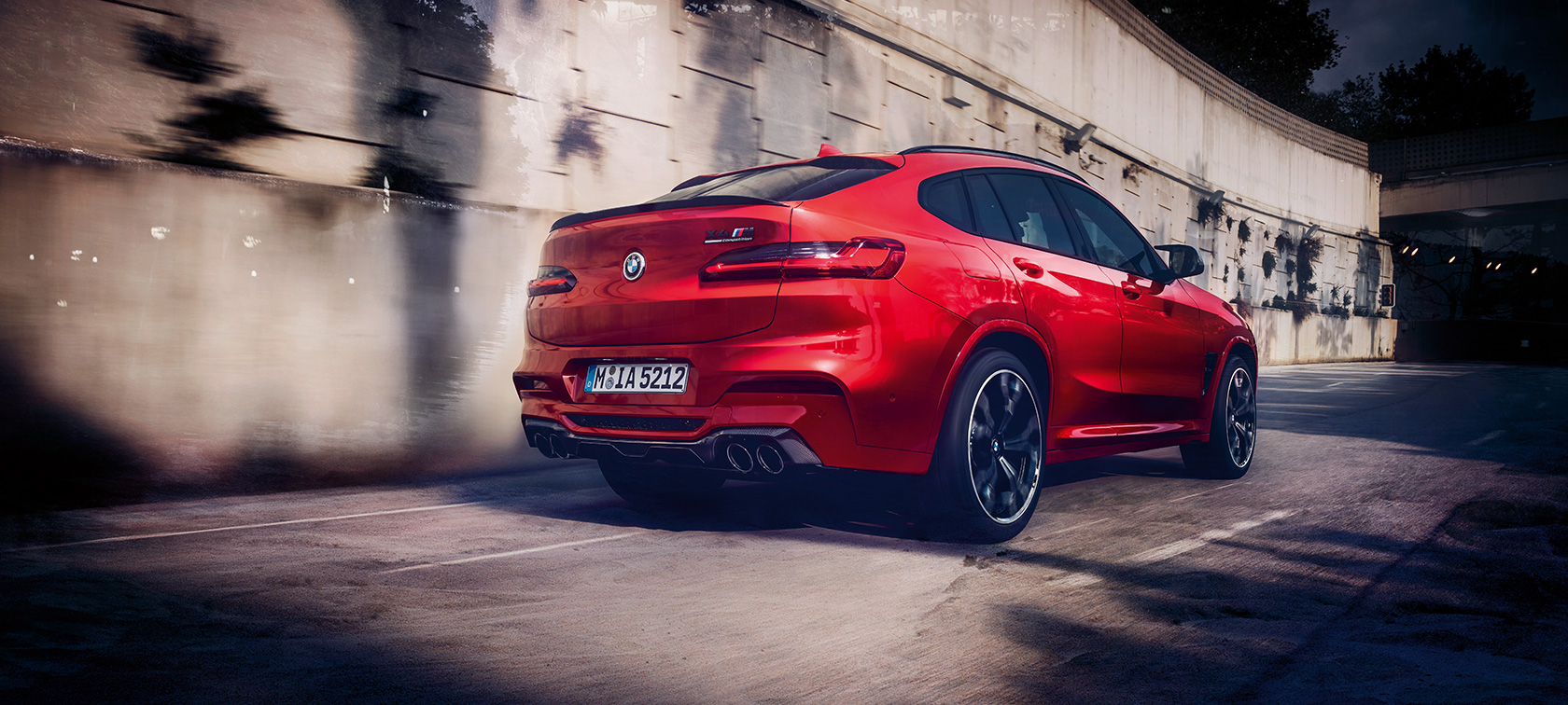 BMW X4 M Competition, три четвърти изглед отзад. BMW X4 M Competition в цвят Toronto Red metallic, в движение, екстериор, три четвърти изглед отзад.