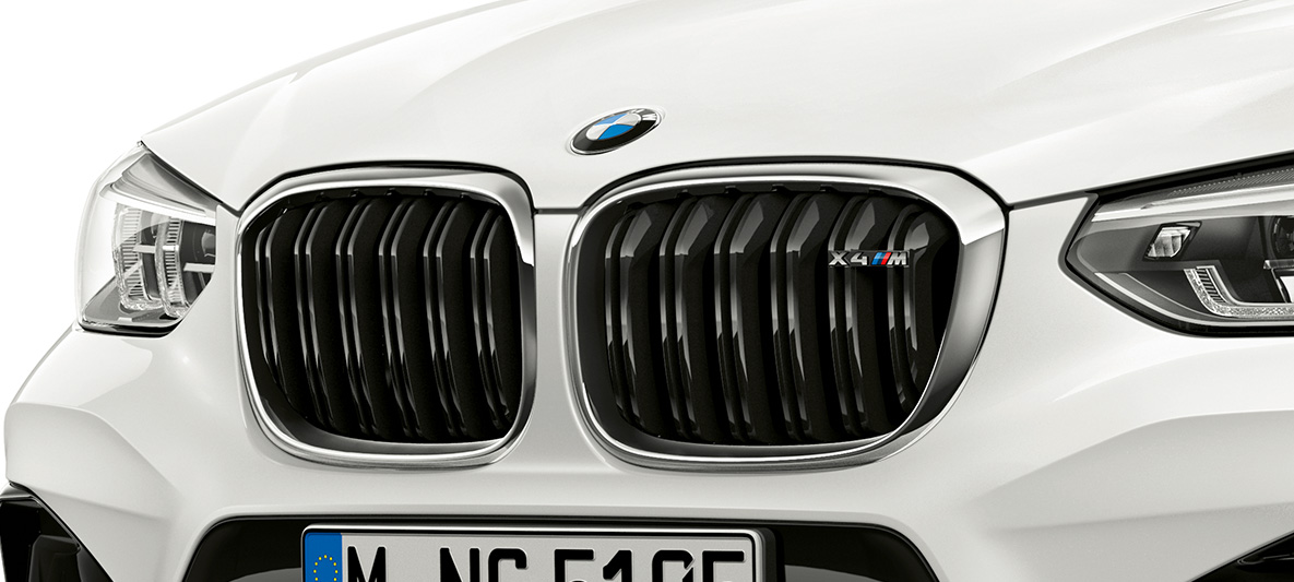 BMW X4 M, М бъбрековидна радиаторна решетка. BMW X4 M в цвят Alpine White, екстериор, предна част, М бъбрековидна радиаторна решетка с хромирани акценти и означение на модела.