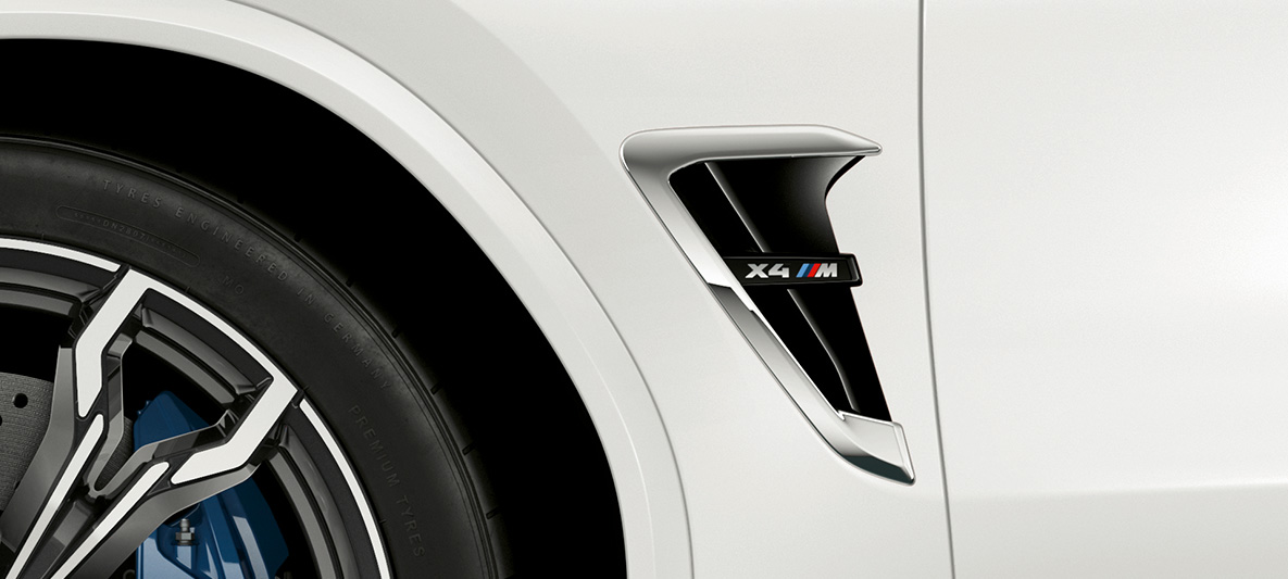 BMW X4 M, М хриле BMW X4 M в цвят Alpine White, екстериор, М хриле с хромирани акценти и означение на модела.