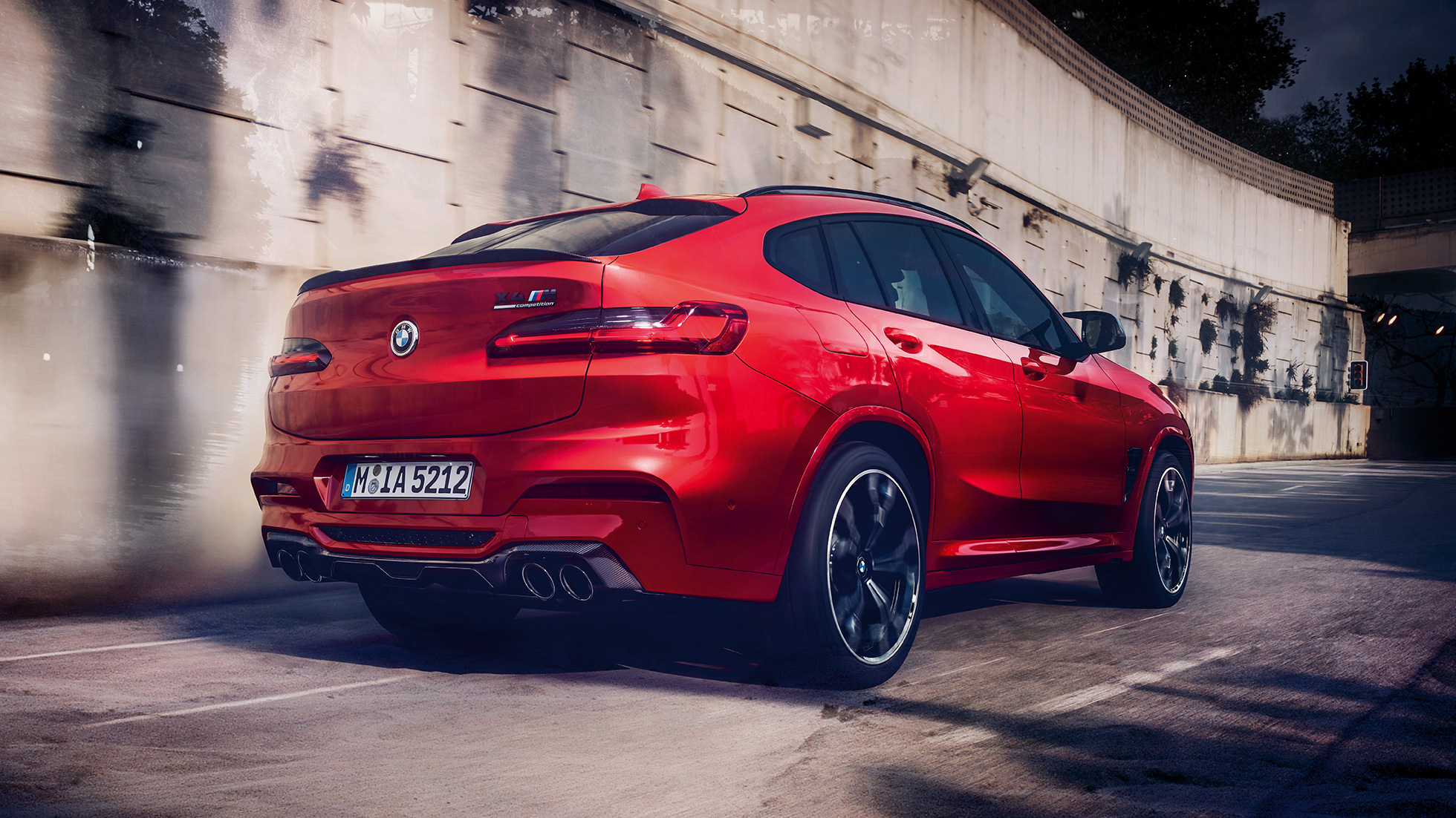 BMW X4 M Competition, страничен изглед отзад. BMW X4 M Competition в цвят Toronto Red metallic, екстериор, страничен изглед отзад.