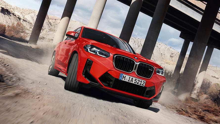BMW X4 M F98 LCI Facelift 2021 Toronto Red metallic три четвърти изглед отпред под колони на мост
