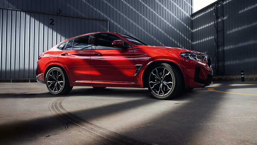 BMW X4 M F98 LCI Facelift 2021 Toronto Red metallic изглед отстрани пред фабрично хале