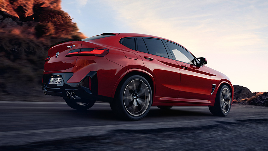 BMW X4 M F98 LCI Facelift 2021 Toronto Red metallic три четвърти изглед отзад в движение по пътя