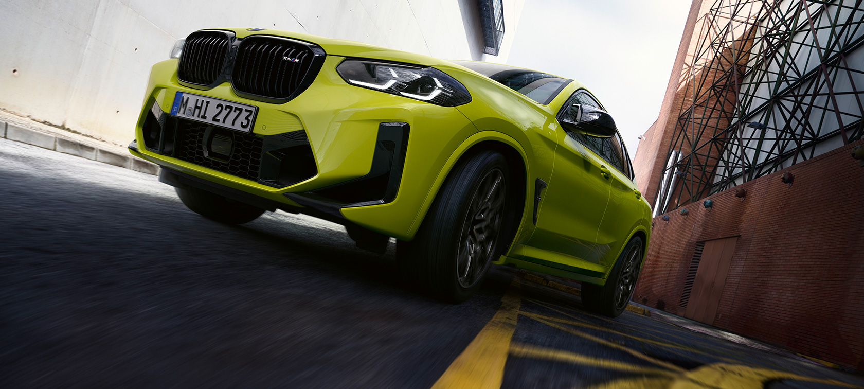Три четвърти изглед отпред, снимка отдолу BMW Х4 М Competition F98 LCI 2021 BMW X4 M Competition F98 LCI Facelift 2021 Sao Paulo Yellow три четвърти изглед отпред, снимка отдолу в движение между къщи