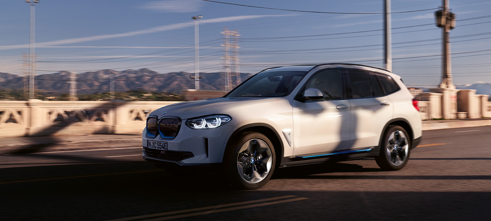 BMW iX3 G08 три четвърти изглед отпред в движение на пътя BMW iX3 G08 2020 Mineral White metallic три четвърти изглед отпред в движение на пътя