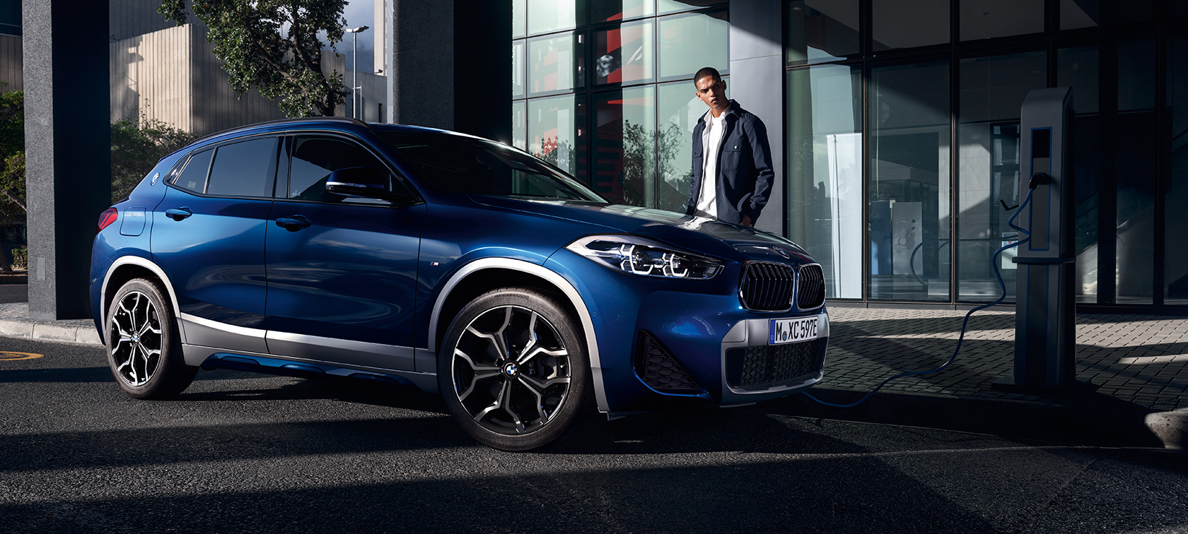 Plug-in хибрид BMW X2 xDrive25e F39 три четвърти изглед отстрани на зарядна станция Plug-in хибрид BMW X2 xDrive25e F39 три четвърти изглед отстрани на зарядна станция с модел