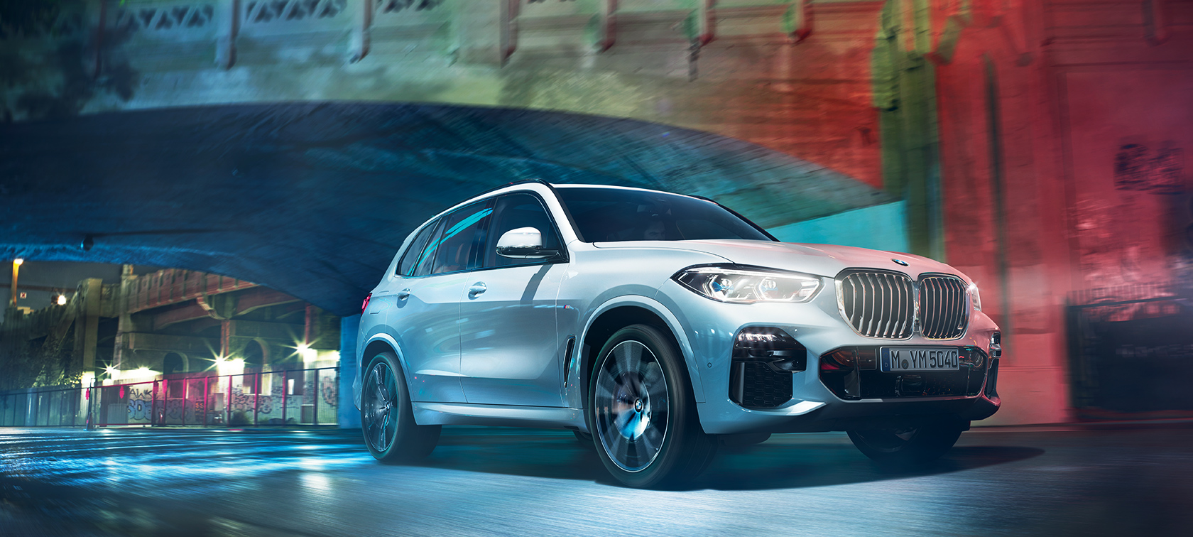 BMW X5 в действие BMW X5 движейки се из града през нощта