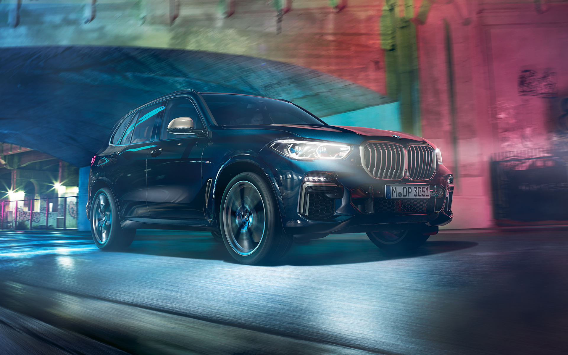BMW X5 M50d в действие Снимка на BMW X5 M50d в движение през нощта на фона на града