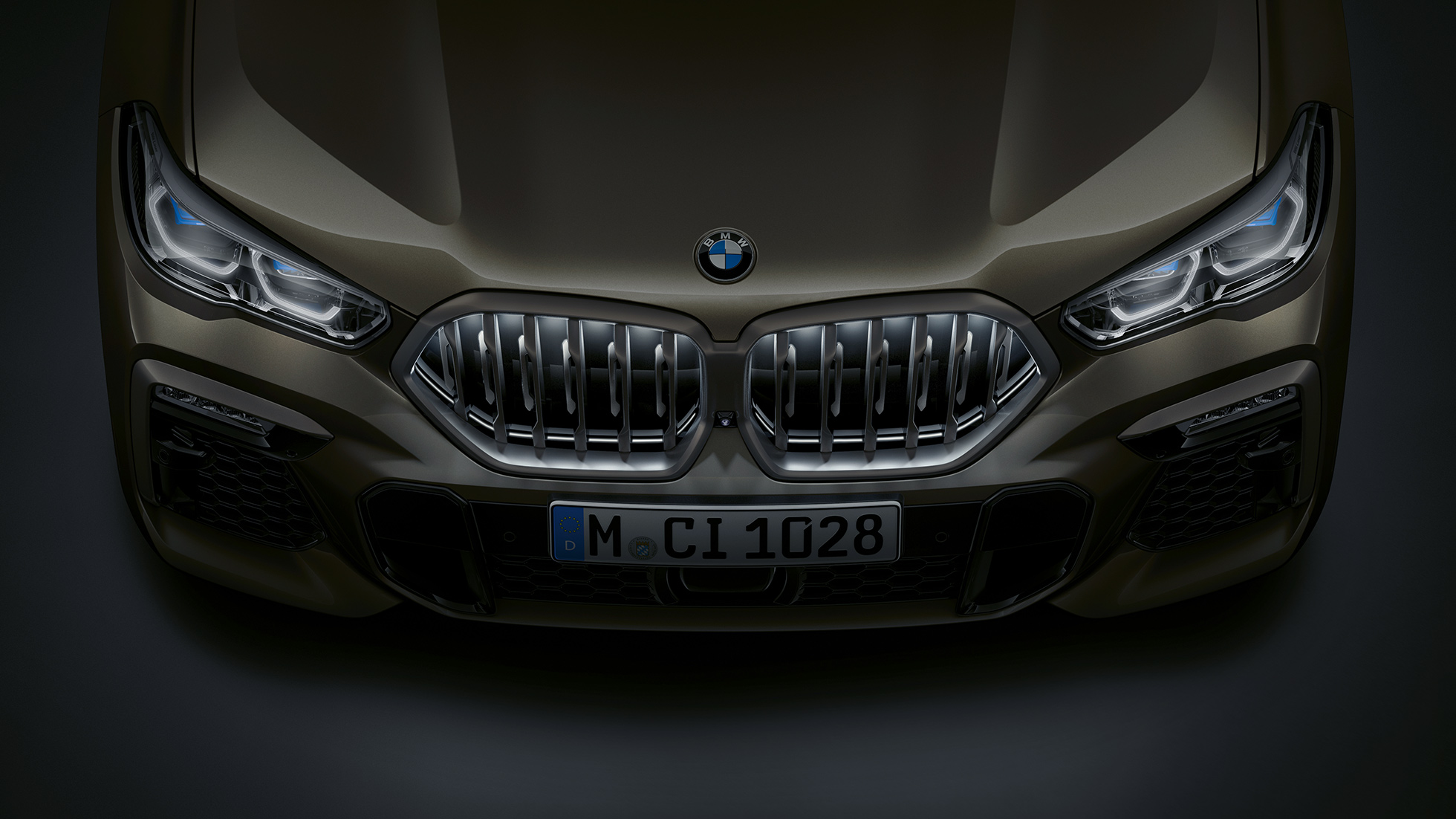 BMW X6 отпред. Снимка отблизо на предната част на BMW X6 с BMW бъбрековидна радиаторна решетка ‘Iconic Glow’ от перспектива „птичи поглед“