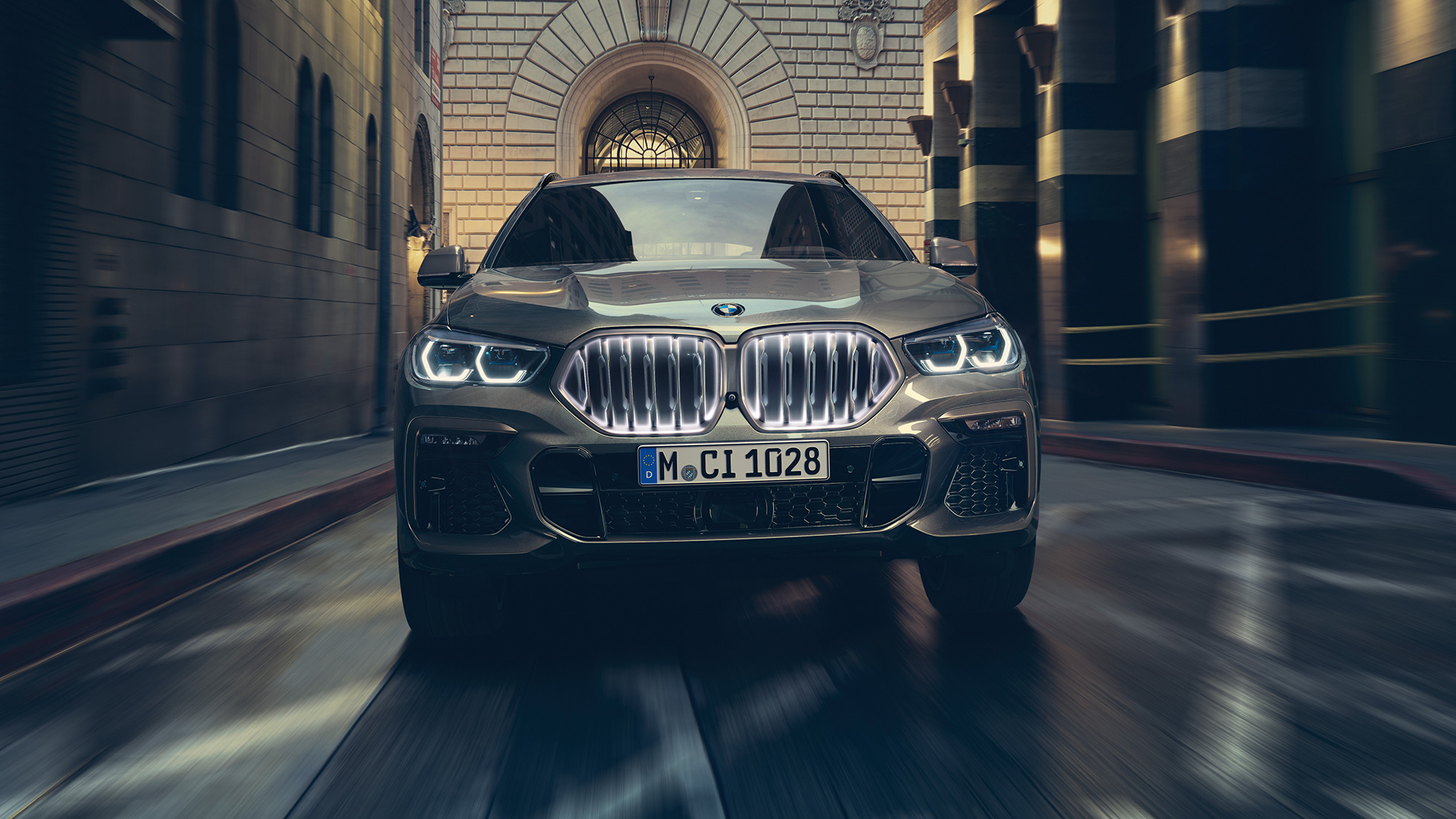 BMW X6 с BMW ‘Iconic Glow’ бъбрековидна радиаторна решетка. BMW X6, изглед отпред на фона на градски пейзаж