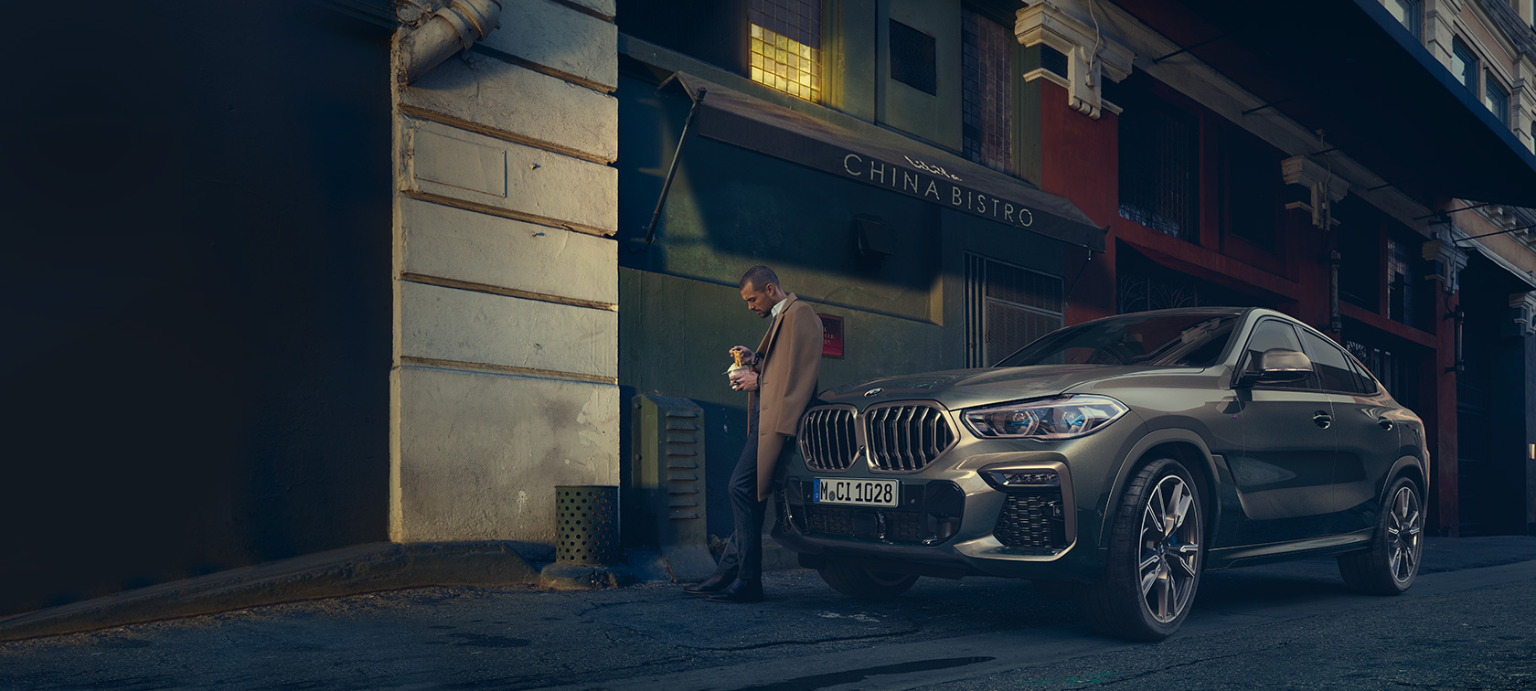 BMW X6 три четвърти изглед отзад в движение BMW X6 G06 2021 Manhatten metallic три четвърти изглед отзад в движение