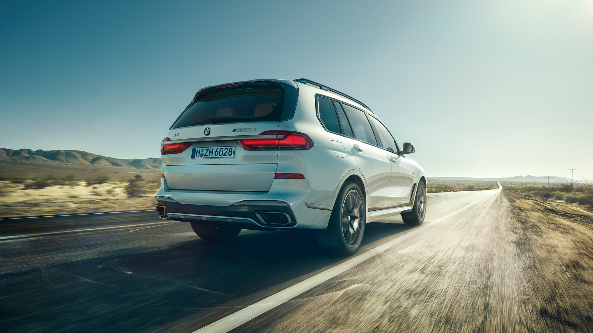 BMW X7 M50d, снимка отзад BMW X7 M50d: снимка отзад на бяло BMW X7 в движение