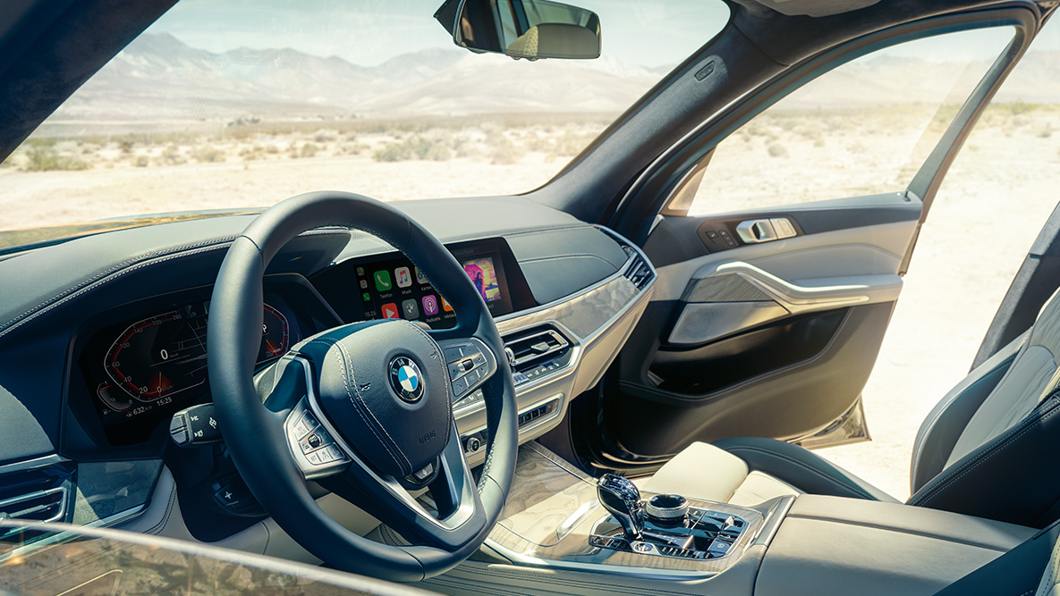 BMW X7 интериор BMW X7 интериор: изглед отвън към първия ред седалки с поглед към волана, арматурното табло и кожените седалки