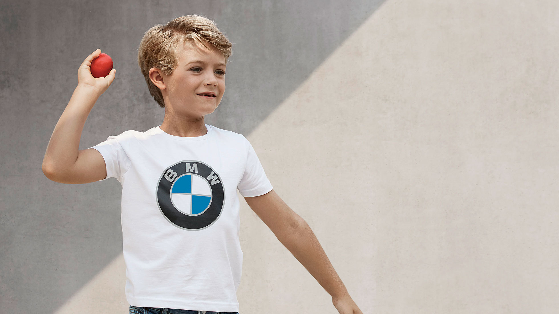 Колекция за деца на BMW. Момче носи продукти от колекцията за деца на BMW.