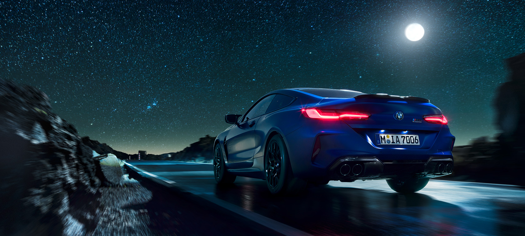 BMW M8 Competition Купе, изглед отзад. BMW M8 Competition Купе, изглед отзад, в движение през нощта при пълнолуние