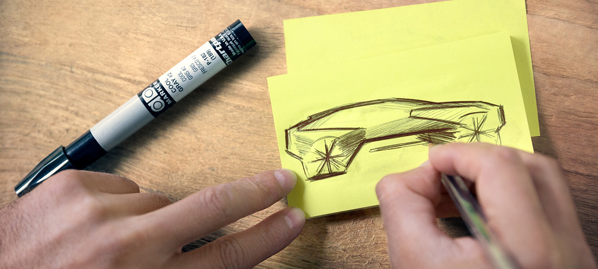 Скица на BMW Vision iNEXT Ръце рисуват скица на BMW Vision iNEXT върху Post-it