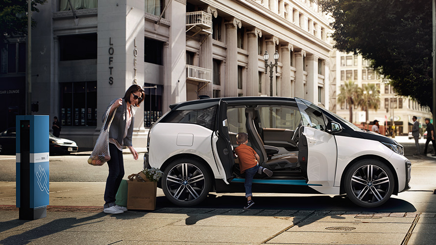 BMW i3 на фона на града BMW пробег BMW i3 на фона на града с жена и дете