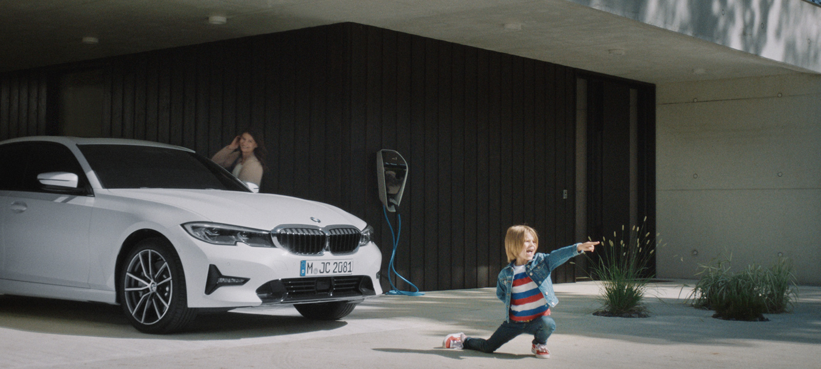 BMW хибриден автомобил на зарядна станция BMW Plug-in хибриди момче пред BMW хибриден автомобил на зарядна станция