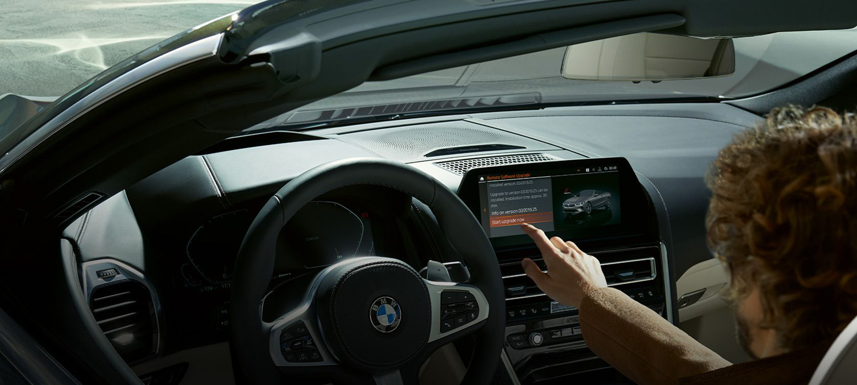 BMW Remote Software Upgrade Мъж седи в BMW и стартира BMW Remote Software Upgrade