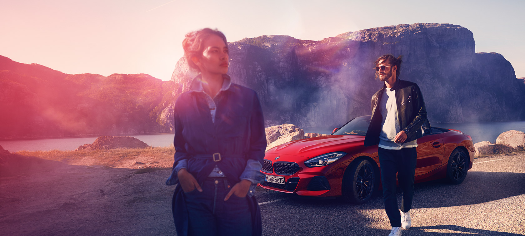 BMW три четвърти изглед отпред на фона на планински пейзаж с мъж и жена BMW Финансови услуги три четвърти изглед отпред на фона на планински пейзаж с мъж и жена