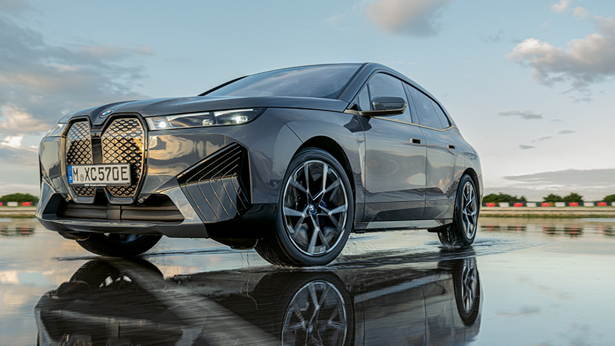 BMW джанти, три четвърти изглед отпред на BMW iX (i20) на мокър път BMW джанти, три четвърти изглед отпред на BMW iX (i20) на мокър път