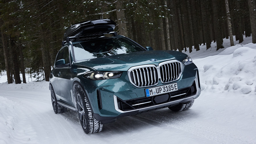 Зимни комплекти колела BMW на BMW X5 (G05 LCI) на заснежен път в гората Зимни комплекти колела BMW на BMW X5 (G05 LCI) на заснежен път в гората