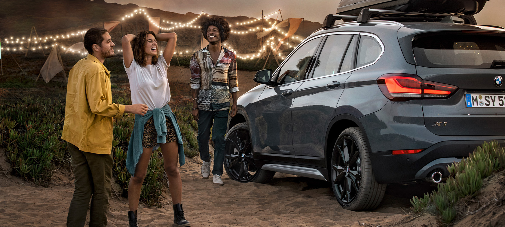 Щастливо трио в BMW X1 с BMW летни оферти Щастливо трио в BMW X1 Mineral Grey, оборудвано с BMW летни оферти три четвърти заден изглед на плажа BMW оборудване