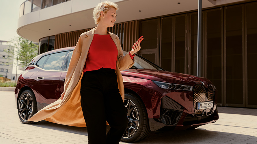 My BMW App жена със смартфон пред BMW Жена със смартфон пред BMW